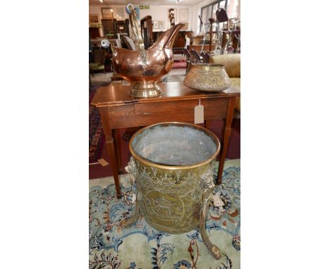 A late 19th/early 20th century Dutch brass planter, repousse decorated with farmyard scenes, having lion head handles, raised