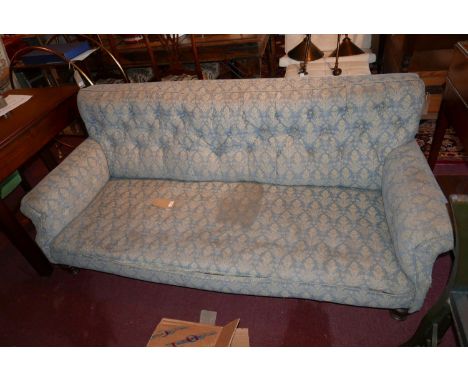 An early 20th century three seater sofa, with floral button back upholstery raised on turned feet 