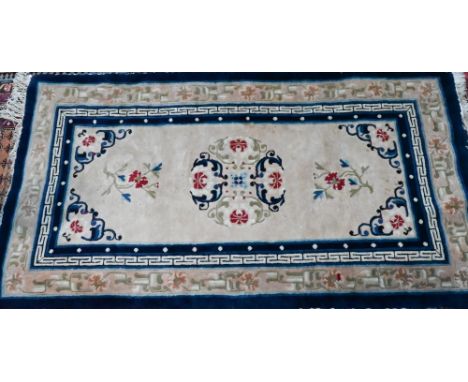 An antique Chinese Peking rug, first quarter 20th century, the camel ground with scattered blue designs, 178 cm x 97 cm 