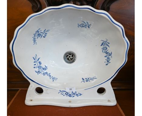 A French faience shell-form hand-basin with floral painted blue and white decoration, by Maurice Herbeam, Lille, 45 cm wide 