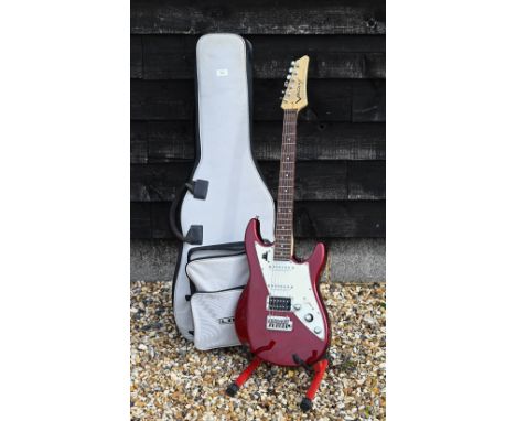 A James Tyler Variax red electric guitar c/w 'Line 6' soft gig bag, 'pilots Handbook', charger and battery on red stand 