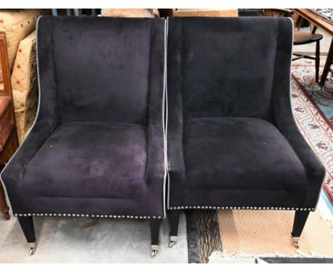 Two 'knocker back' lounge chairs in velveteen fabric with tapering front legs with chromed casters - note - chairs non matchi