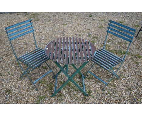 A contemporary distress painted circular garden table and pair of chairs (3) 