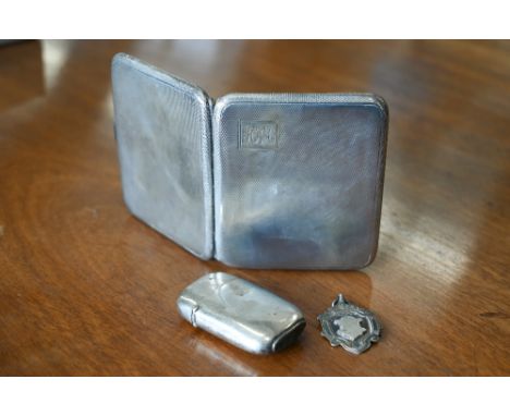 An engine-turned silver cigarette case, Birmingham 1927, to/w a vesta case, London 1894 and a silver sports medallion (3), 4 