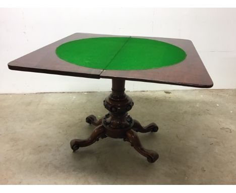 A Victorian mahogany swivel top card table with carved pedestal base on original castors. W:91cm x D:91cm x H:70cm