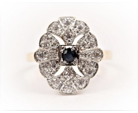 A hallmarked 9ct yellow gold sapphire and cubic zirconia ring, set with a central round cut sapphire surrounded by open metal