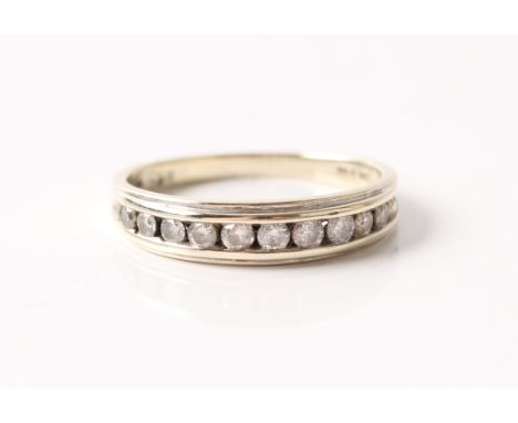 A hallmarked 9ct white gold diamond half eternity ring, channel set with eleven graduated round brilliant cut diamonds, total