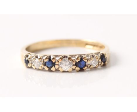 A hallmarked 9ct yellow gold sapphire and diamond half eternity ring, set with four round cut sapphires and three graduated r