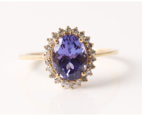 A hallmarked 9ct yellow gold tanzanite and diamond ring, set with an oval cut tanzanite measuring approx. 9x7mm, surrounded b