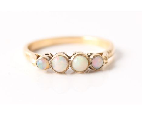 A four stone opal ring, set with four graduated round opal cabochons, unmarked yellow metal, ring size O 1/2