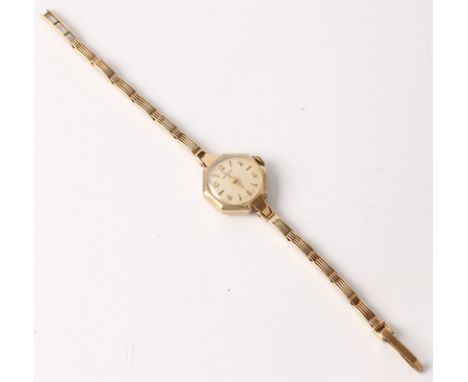 A hallmarked 9ct yellow gold Garrard ladies wrist watch, the cream dial having alternating Arabic and arrow markers, on a hal