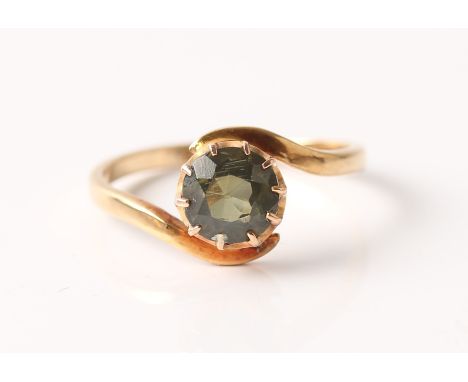 A green single stone ring, in cross over design band, stamped 18ct, ring size L