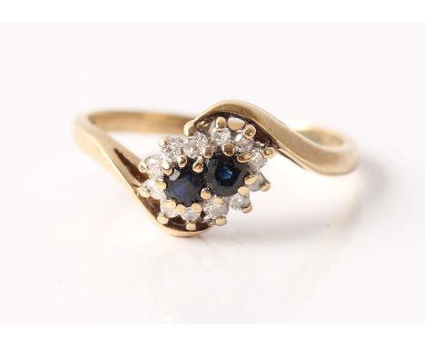 A sapphire and diamond cluster ring in cross over design, hallmark rubbed, ring size L