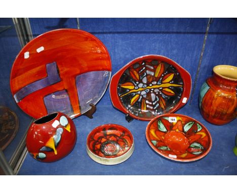 Seven pieces of Poole Pottery, to include a Delphis bowl, a shallow bowl, a purse vase and a charger, 40cm in diameter 