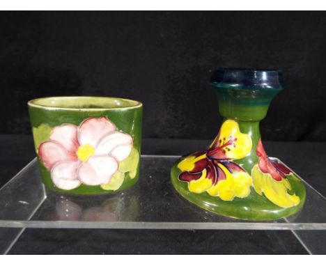 Moorcroft - a Moorcroft Pottery dwarf candlestick decorated with hibiscus on a green ground, approximately 8 cm (h) and a sma
