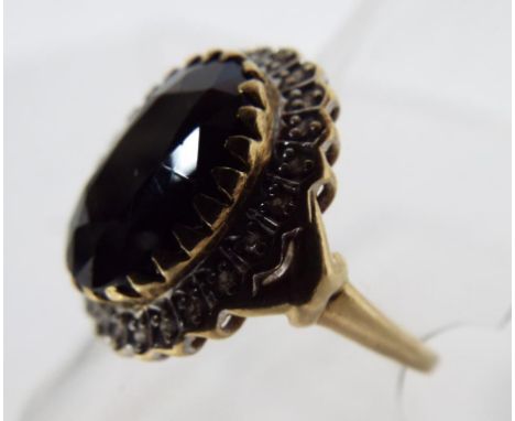 A 9 carat gold ring with black stone and diamonds, size of the ring is R and the weight is 5.05 g. Estimate £60 - £80