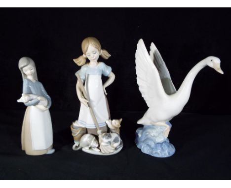 Lladro - Two Lladro figurines comprising # 5232 'Playful Kittens', # 1011 'Girl with Piglet' and a Nao figurine depicting a s