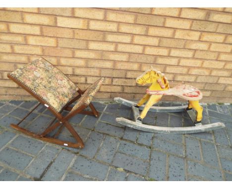 A child's vintage rocking horse and a child's folding rocking chair with upholstered seat and back.