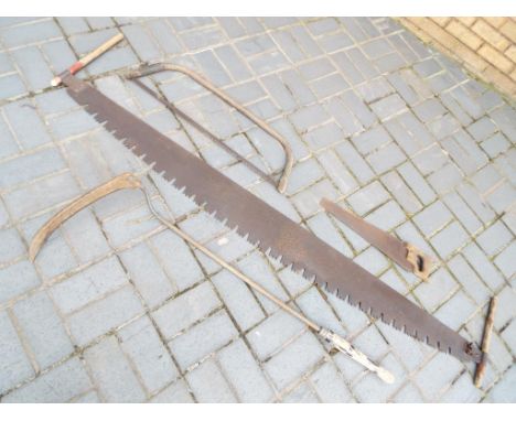 A collection of vintage tools, including three saws and a scythe [4].