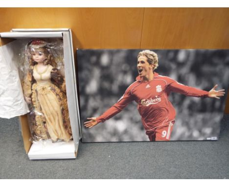 A signed canvas print depicting Fernando Torres with certificate of authenticity and a House of Berkeley porcelain head doll 