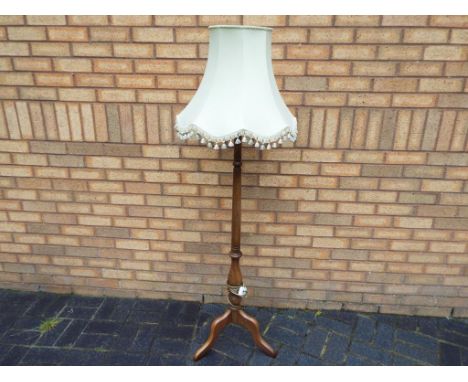 Ercol - a mid-elm Ercol standard lamp with neutral coloured shade bearing Ercol stamp to the foot, appears to be in excellent