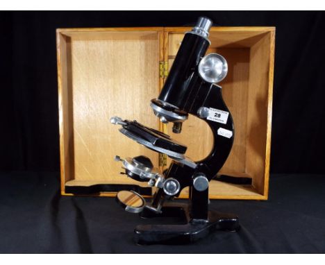 A large vintage microscope contained in wooden protective carry case