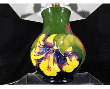 Moorcroft Pottery - a table lamp decorated in the coral hibiscus pattern on a green ground with green shade, the lamp base ap