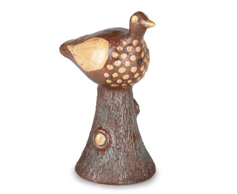 AN EARLY 19TH CENTURY SLIPWARE BIRD WHISTLE possibly Halifax, modelled perching upon a tapering trunk, in brown and cream gla