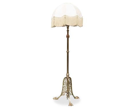 AN EDWARDIAN BRASS TELESCOPIC STANDARD LAMP the tripod base with paw feet. 170cm high to top of shade, but adjustable