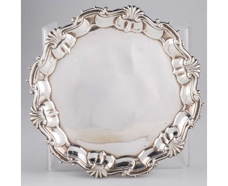 A GEORGE II SILVER WAITER by Hugh Mills, London 1747, shaped circular form with shell and scroll-form rim, raised on C-scroll