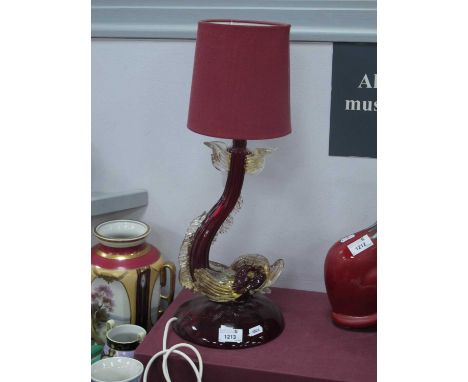 A Murano Ruby Glass Dolphin Table Lamp, with aventurine flecked detail, on a circular base, 34cm high without shade, 50cm hig