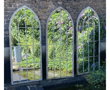 ARCHITECTURAL GARDEN MIRRORS, a set of three, aged metal frames, gothic style arch design, 160cm x 67cm. (3) 