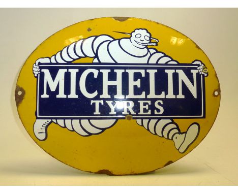 A scarce enamel advertising sign for 'Michelin Tyres', features the early 'Smoking Bibendum' carrying a board reading 'Michel