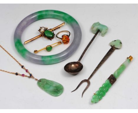 A collection of jade jewellery and an amber ring to include a jade bangle, a jade pendant on yellow metal chain, a jade brooc