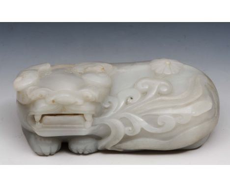 A Chinese white jade lion Ming with carved fungus and flower head, 15cm long