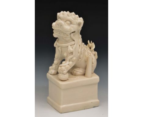 A Chinese blanc de chine porcelain joss stick holder 17th Century a Buddhistic lion resting its front paw resting on a ball, 