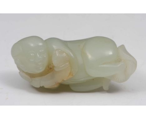 A Chinese pale celadon jade figure of a youth with a puppy 18th Century the boy's rounded head with hair bunched on both side