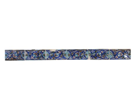 A Persian tile panel made up of six blue ground tiles with foliate decoration, 124cm x 10cm