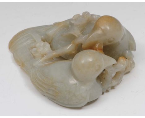 A Chinese mutton fat jade pebble 18th Century carved as a pair of exotic love birds nesting and holding between them a cherry