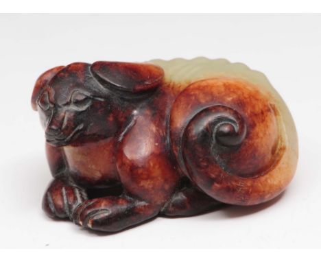 A Chinese jade dog 18th/19th Century its body and legs curled together, with brown colouring, 5cm