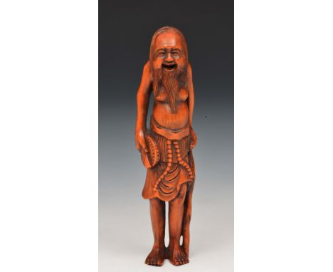 A Japanese wood netsuke of a smiling figure 19th Century signed Kogyoku, the figure wearing a loin cloth and holding a drum a