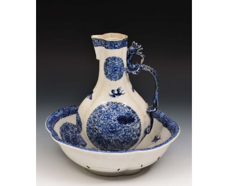 A Chinese porcelain export jug and basin Qianlong underglaze blue panels of peonies and with dragon handle, the basin of quat