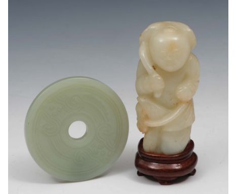 A Chinese white jade figure of a standing youth and a Chinese jade bi ring 18th/19th Century the youth with a hobby horse and