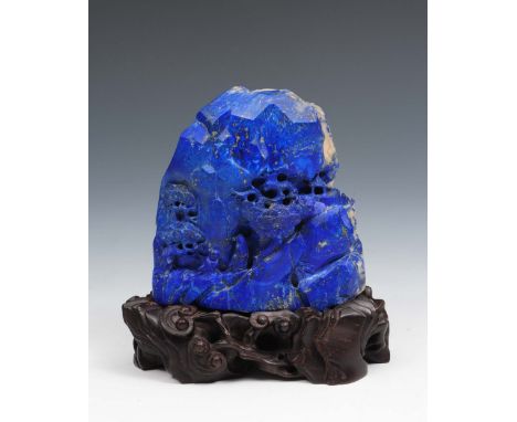 A Chinese lapis lazuli boulder 19th Century carved one side with scholars beneath pine trees, the reverse with stag resting o
