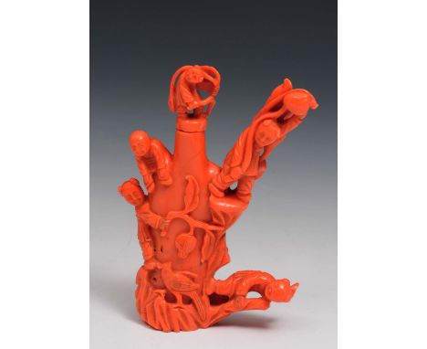 A Chinese coral snuff bottle the central bottle having a group of boys around the body and the finial, some carrying peaches 