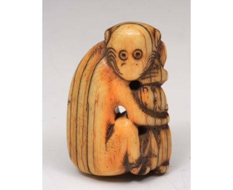 A Japanese ivory netsuke Edo period  of a monkey clutching a dog, 4.5cm high