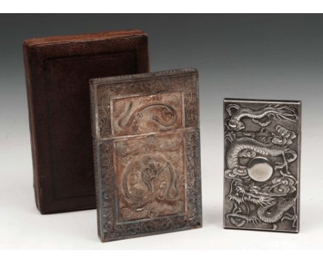 A Chinese silver filigree card case decorated with two dragons to each side flying amongst clouds within a pierced foliate bo