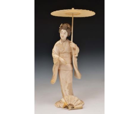 A Japanese ivory okimono of a standing Geisha Meiji period Signed Meiichi, the Geisha holding an open fan and umbrella, 22cm 