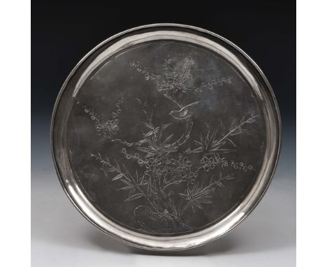 A Chinese silver salver late 19th Century with rounded rim and supported on four ball feet, engraved with bird perched upon a