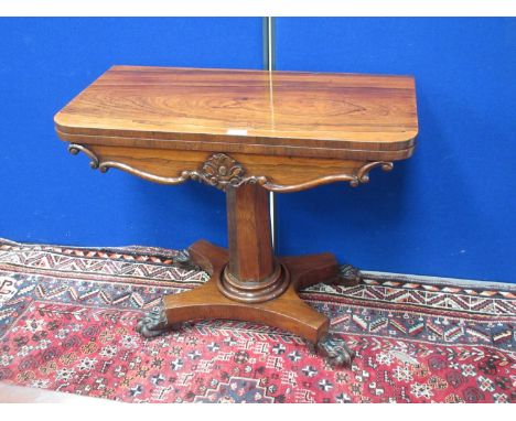 A 19th Century rosewood Card Table with fold-over top on octagonal column, the platform base with carved claw supports 